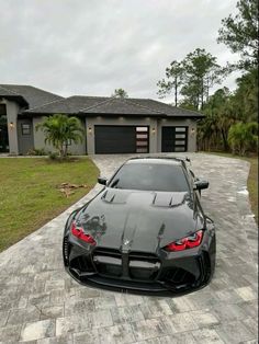 a black sports car parked in front of a house