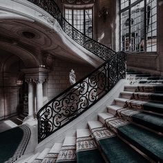 an ornate staircase with wrought iron railing and handrails in a large, historic building