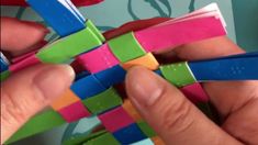 a person is holding several pieces of colored paper in one hand and two fingers on the other