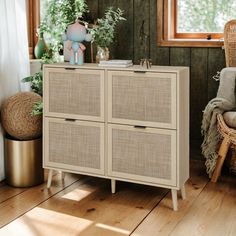 a wicker cabinet sitting next to a window