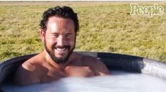 a man is smiling while sitting in a hot tub