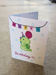 a birthday card with a dinosaur holding a balloon