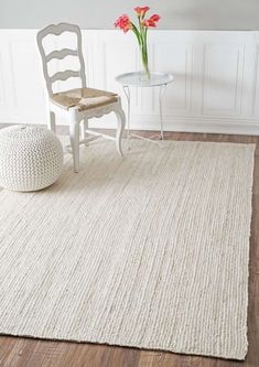 a white rug with a chair and table in the background