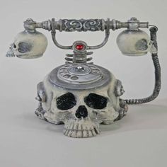 an old fashioned telephone with a skull on it's head and two red eyes