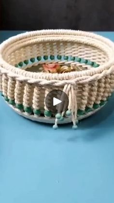 a close up of a white and green basket on a blue table with an elephant figurine