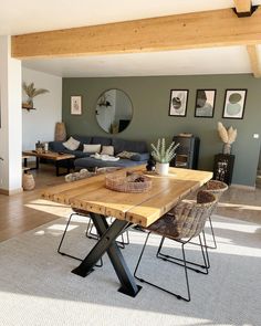 a living room filled with furniture and a wooden dining table in front of a couch