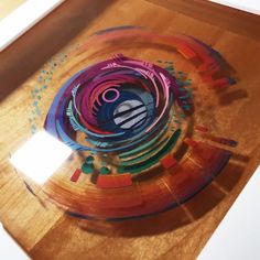 a glass plate with an abstract design on the top and bottom, sitting on a wooden table