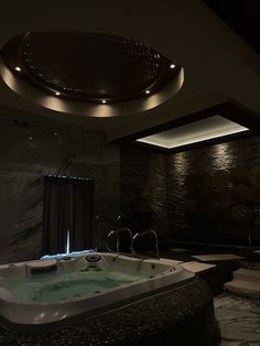 a large jacuzzi tub in the middle of a room with lights on it