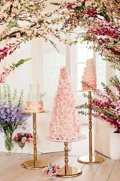 three tiered cake stands with pink flowers on them