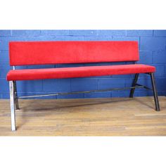 a red bench against a blue brick wall