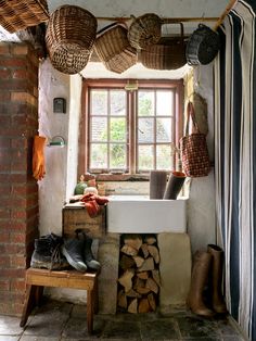 a bathroom with a sink and several baskets hanging from the ceiling over it's windows