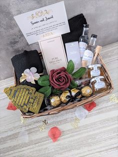 a basket filled with chocolates, wine and other items on top of a table