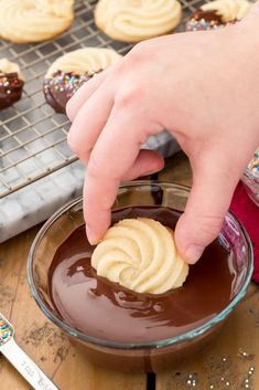 a person dipping some kind of cookie into chocolate