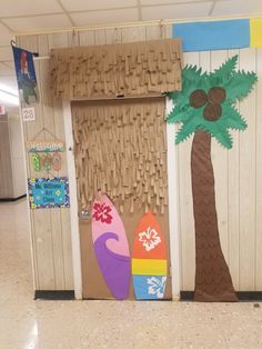 some surfboards and palm trees are painted on the wall in this classroom hallway area