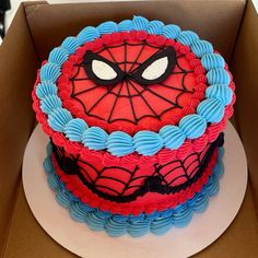 a spiderman cake sitting in a box on top of a table