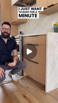 a man sitting on top of a kitchen counter next to an oven and stovetop