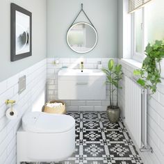 a bathroom with black and white tile flooring next to a plant on the wall