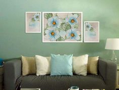 a living room filled with furniture and paintings on the wall above it's coffee table