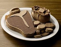 a white plate topped with pieces of chocolate next to an open heart shaped cookie on top of a wooden table