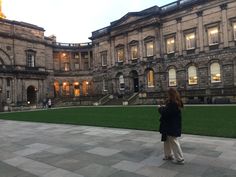 a woman standing in front of a large building