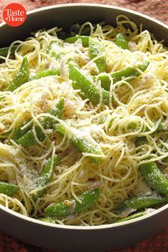 pasta with green beans and parmesan cheese in a white bowl on a red tablecloth