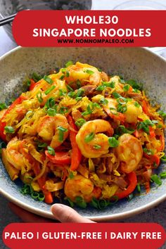 a bowl full of shrimp and vegetables with the words whole 30 singapore noodles