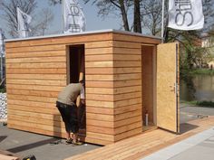 a man standing outside of a small wooden building