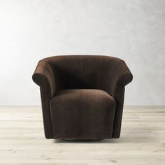 a brown chair sitting on top of a hard wood floor next to a white wall