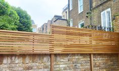 a wooden fence next to a brick wall