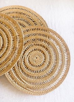 three woven placemats sitting on top of a white table