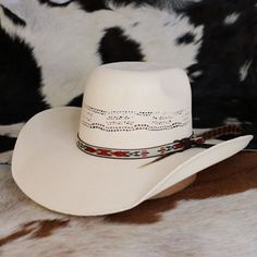 The Resistol Young Gun Jr. Youth Cowboy Hat combines style and durability with its rough-and-tough Bangora construction, featuring a 4 3/4" rounded brick crown and a 4” brim. The hat's unique design includes a feather and a Native American-inspired pattern on the hatband, making it a standout accessory for young cowboys and cowgirls. With an elastic sweatband to accommodate size changes, this hat is a versatile and practical choice for children as they grow and explore the great outdoors. Brim - 4" Crown - 4 1/4" Bangora Straw Adjustable Western Felt Hat For Country Events, White Country Straw Hat For Rodeo, White Western Sun Hat With Flat Brim, Western White Hat With Curved Brim, White Western Style Sun Hat With Flat Brim, White Western Hat With Short Brim, Country Style Hat With Flat Crown For Country Events, White Flat Brim Hat For Ranch, Western Style Adjustable Felt Hat For Rodeo