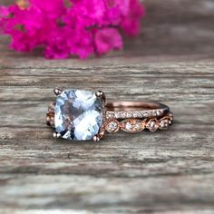 an engagement ring with a blue topazte surrounded by white and rose gold diamonds