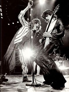 the rolling stones performing on stage in black and white with one man holding a microphone