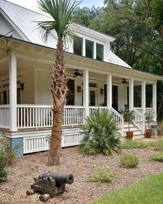 a white house with porches and palm trees