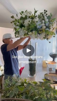 a man arranging flowers in a vase on top of a table with the words, use glue does to secure arrangement