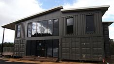 a building made out of shipping containers sitting on the side of a road