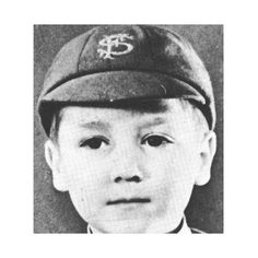 a black and white photo of a young boy wearing a baseball cap with a dollar sign on it