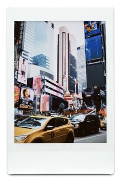 a city street filled with lots of tall buildings and cars driving down it's sides