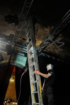 a man standing on top of a ladder