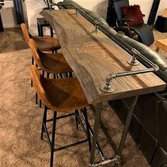 a wooden table with metal legs and barstools in a room filled with furniture