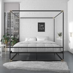 a bedroom with white walls and flooring has a four poster bed frame, along with a rug on the floor