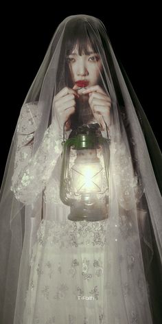 a woman in a wedding dress holding a lantern