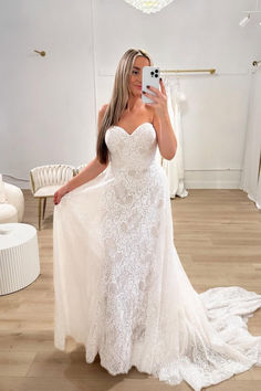 a woman is taking a selfie in her wedding dress while wearing a white gown