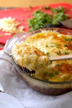 a casserole dish with cheese and parsley on the side, ready to be eaten