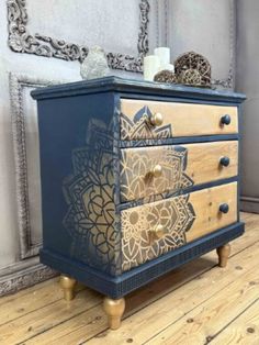 a blue and gold dresser sitting on top of a wooden floor