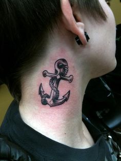 a woman with a tattoo on her neck has an anchor and skull behind the ear