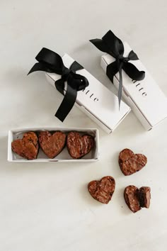 three heart shaped cookies in a white box