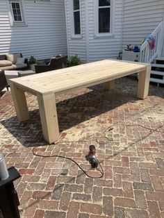 a wooden table sitting on top of a brick patio