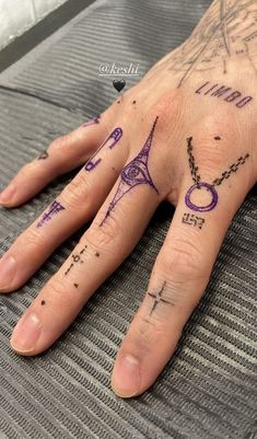 a person's hand with tattoos on it and the word paris written in purple ink