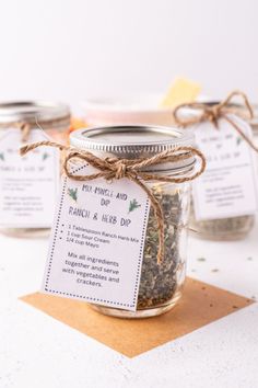 three mason jars filled with herbs on top of a table